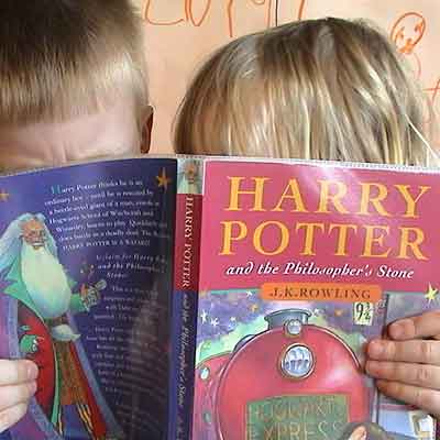 Harry Potter Children eagerly reading a Harry Potter book.
